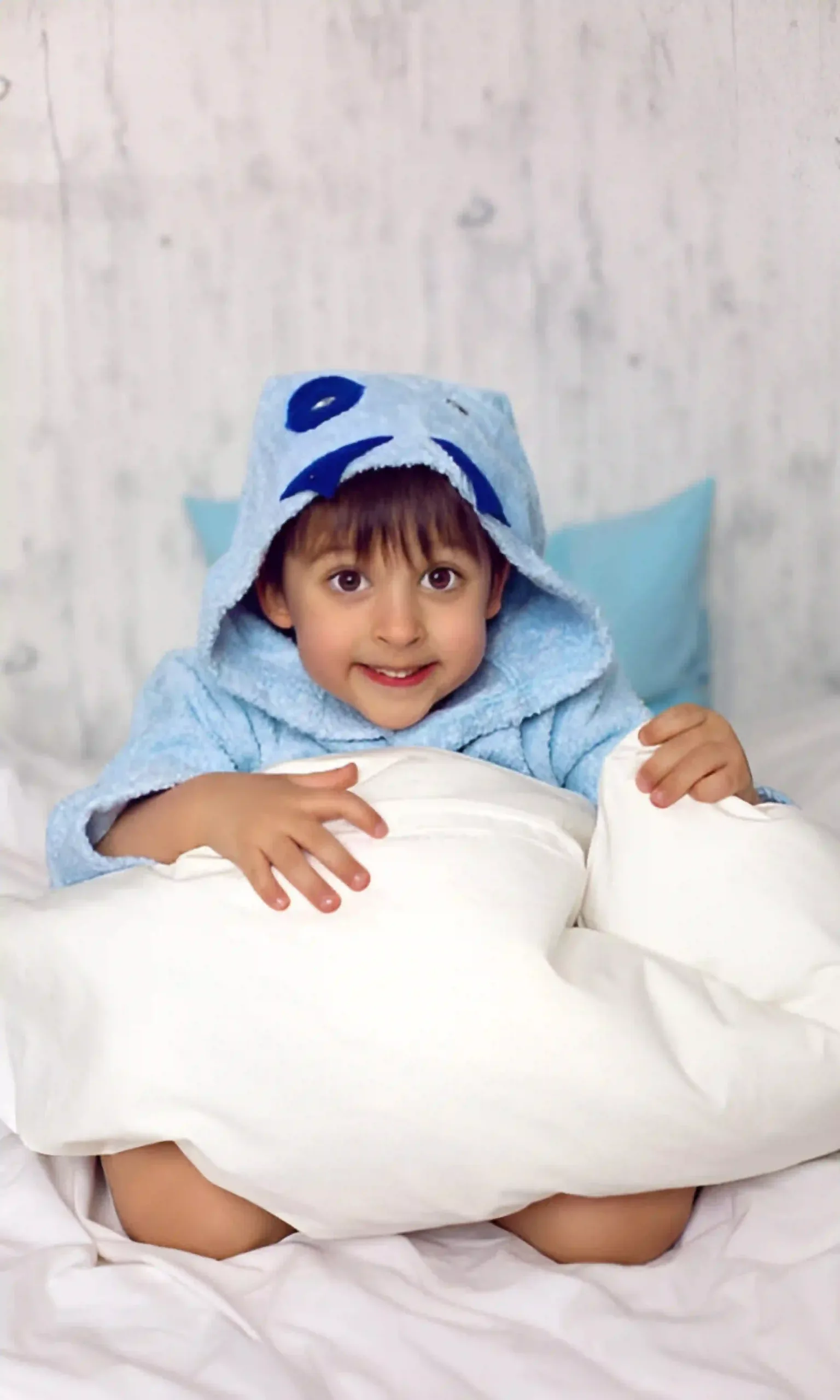 Happy baby boy lying on premium soft kids bedding by Elite Kids Bedding